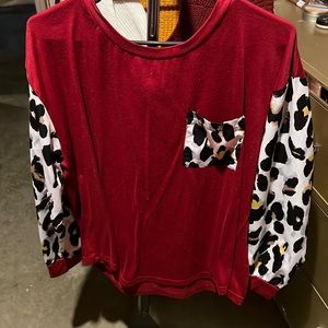 Red shirt with cheetah print sleeves, and pocket